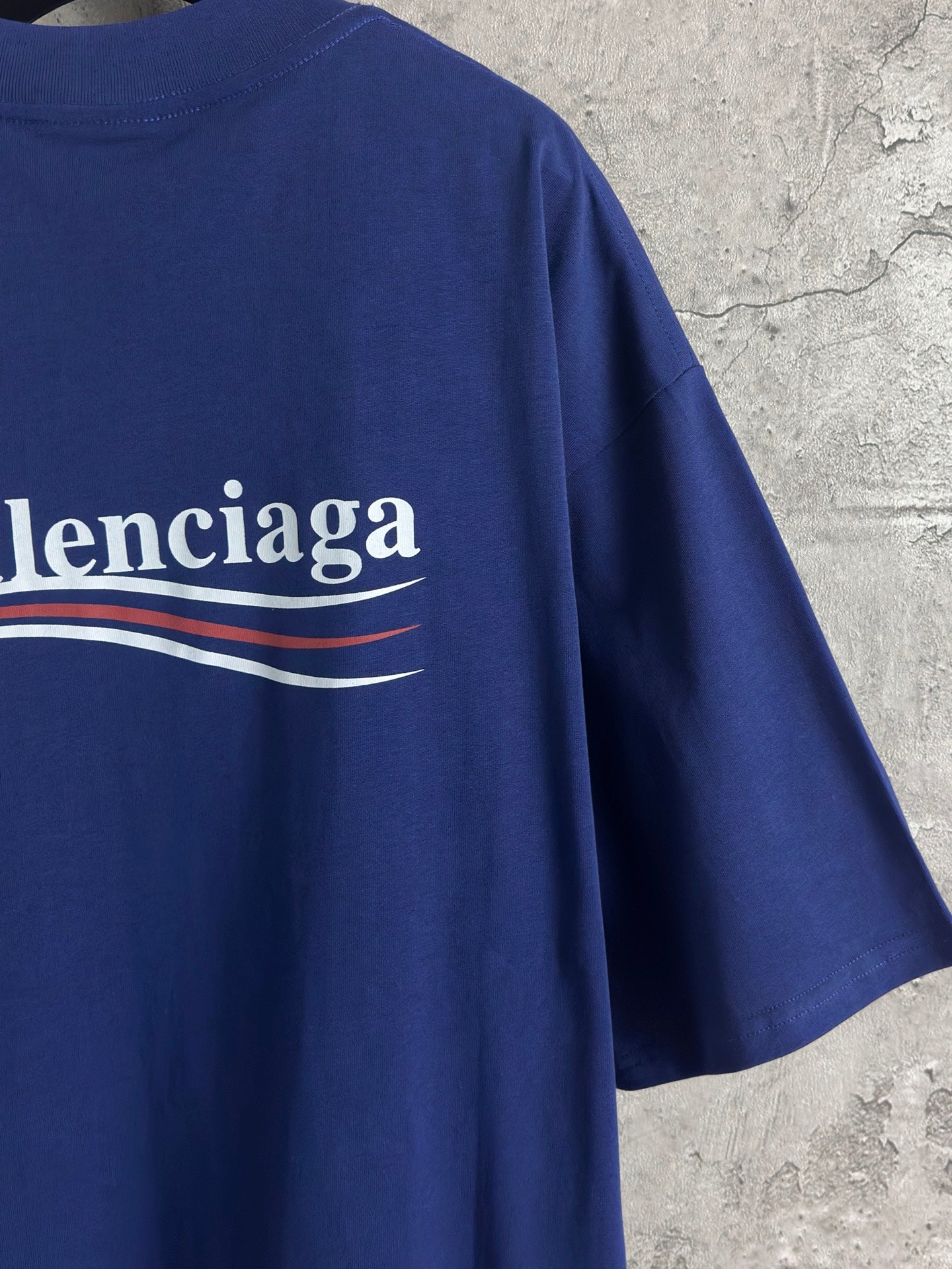 Blue Balenciaga logo graphic across back of crew-neck T-shirt, with striped underline.