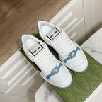 Gucci unisex sneakers with white uppers, blue trim, and green-red stripe on panels