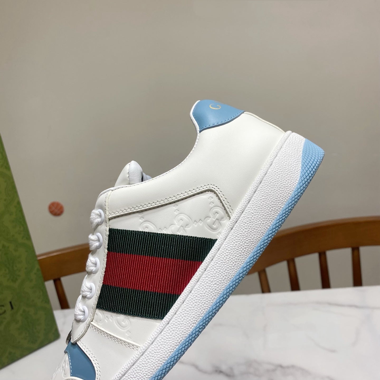Gucci unisex sneaker close-up: white upper with green-red stripe and blue edge sole