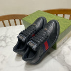 Gucci unisex sneakers on box; black leather with red-and-blue side web stripe and laces.