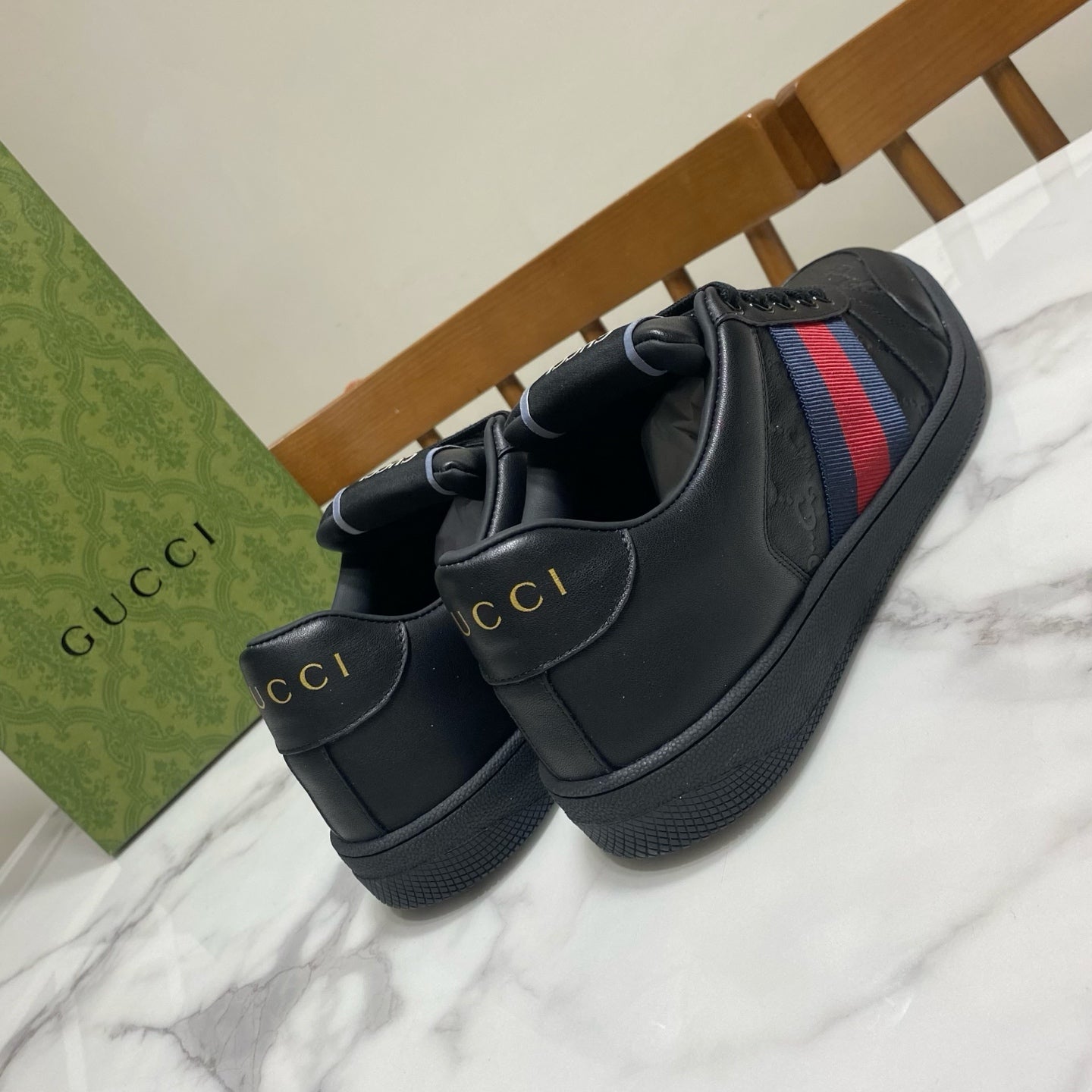Gucci unisex sneakers, heel view; black leather with multicolor side web stripe.
