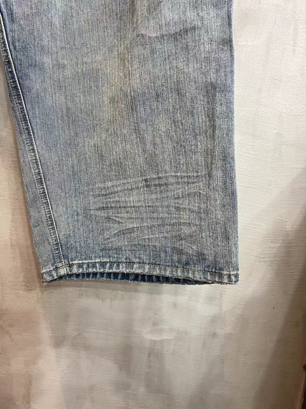 Light blue denim pant leg with straight hem and subtle fade lines