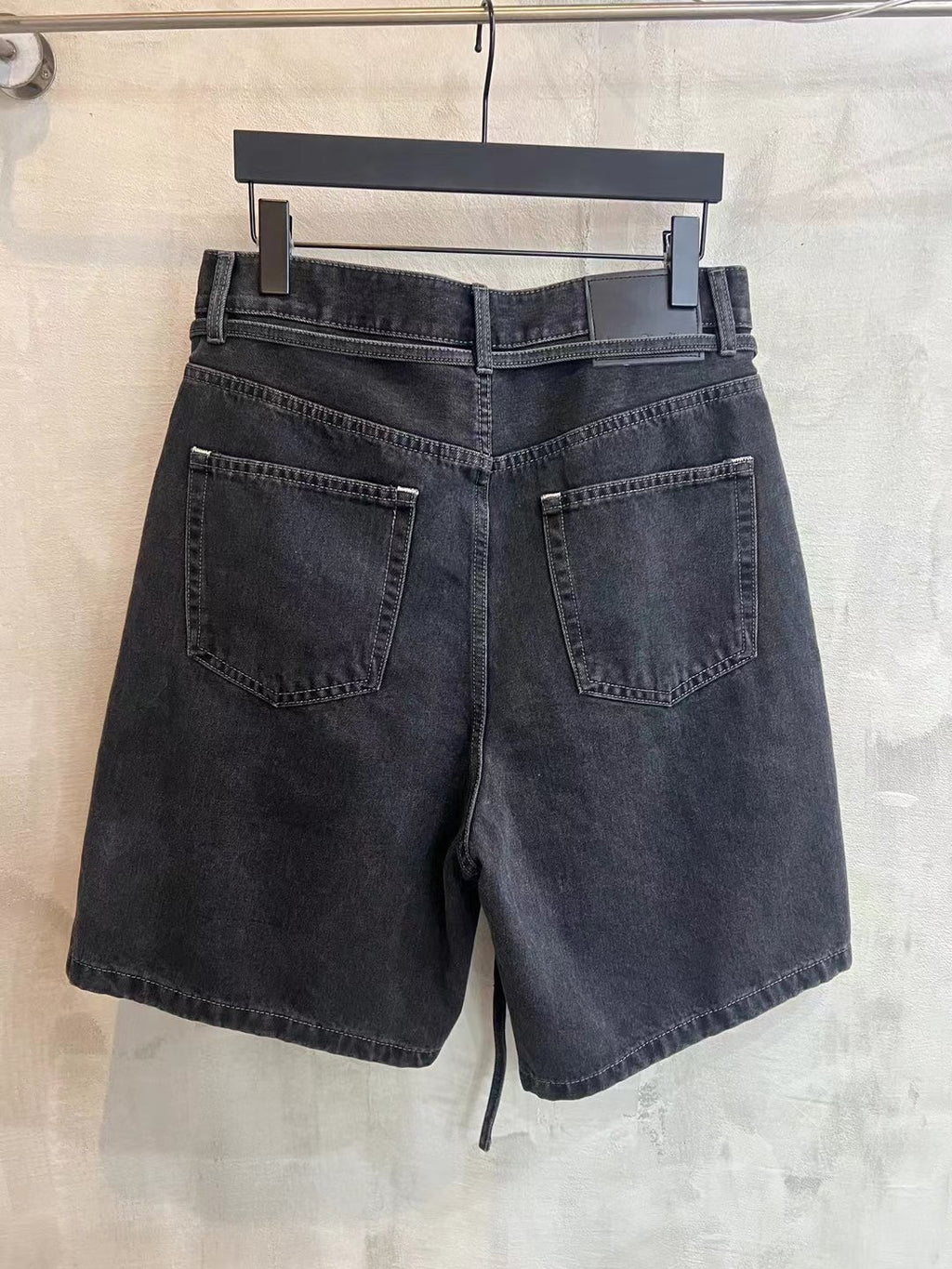 Dark denim shorts with belt loops and two front flap pockets, tied waist drawstring