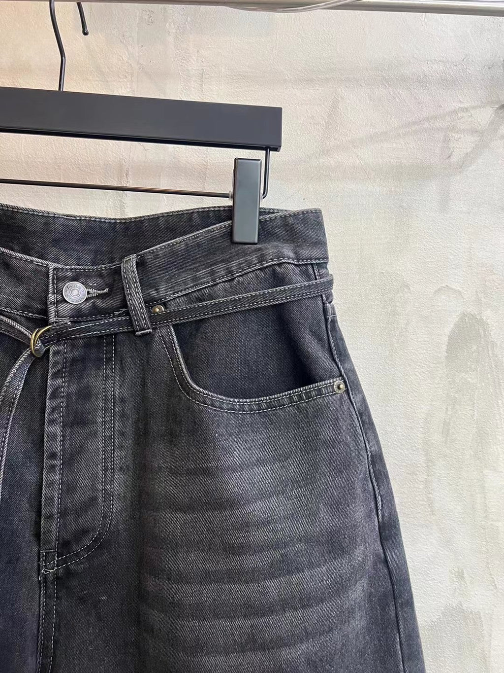 Dark wash denim shorts front detail with button fly, coin pocket, and tied waist drawstring