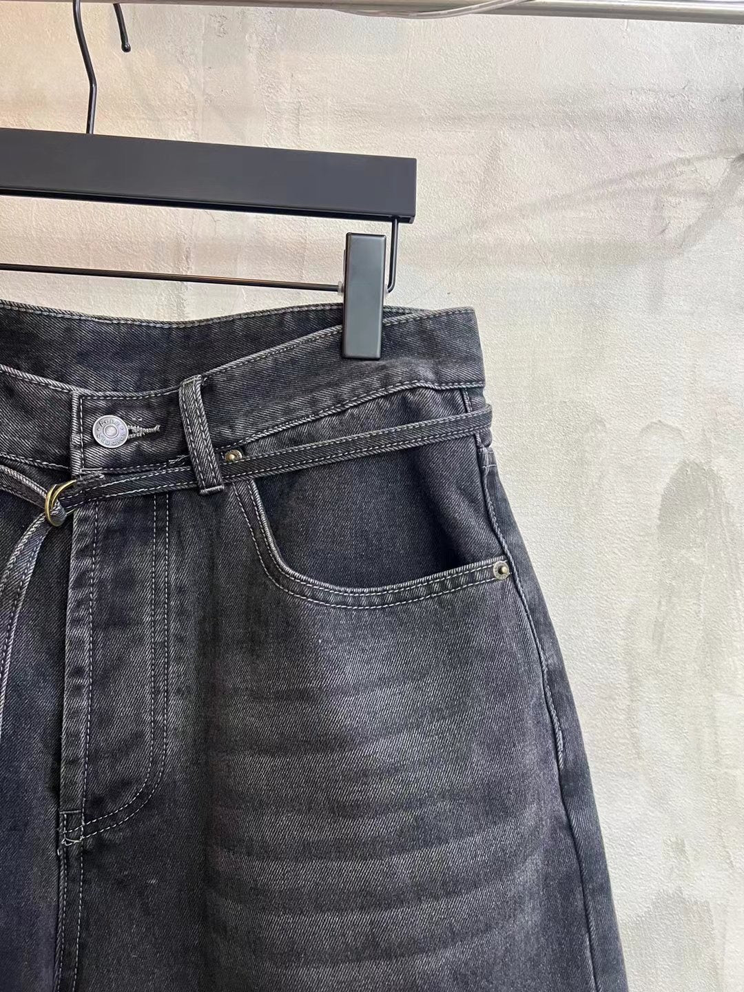Dark wash denim shorts front detail with button fly, coin pocket, and tied waist drawstring