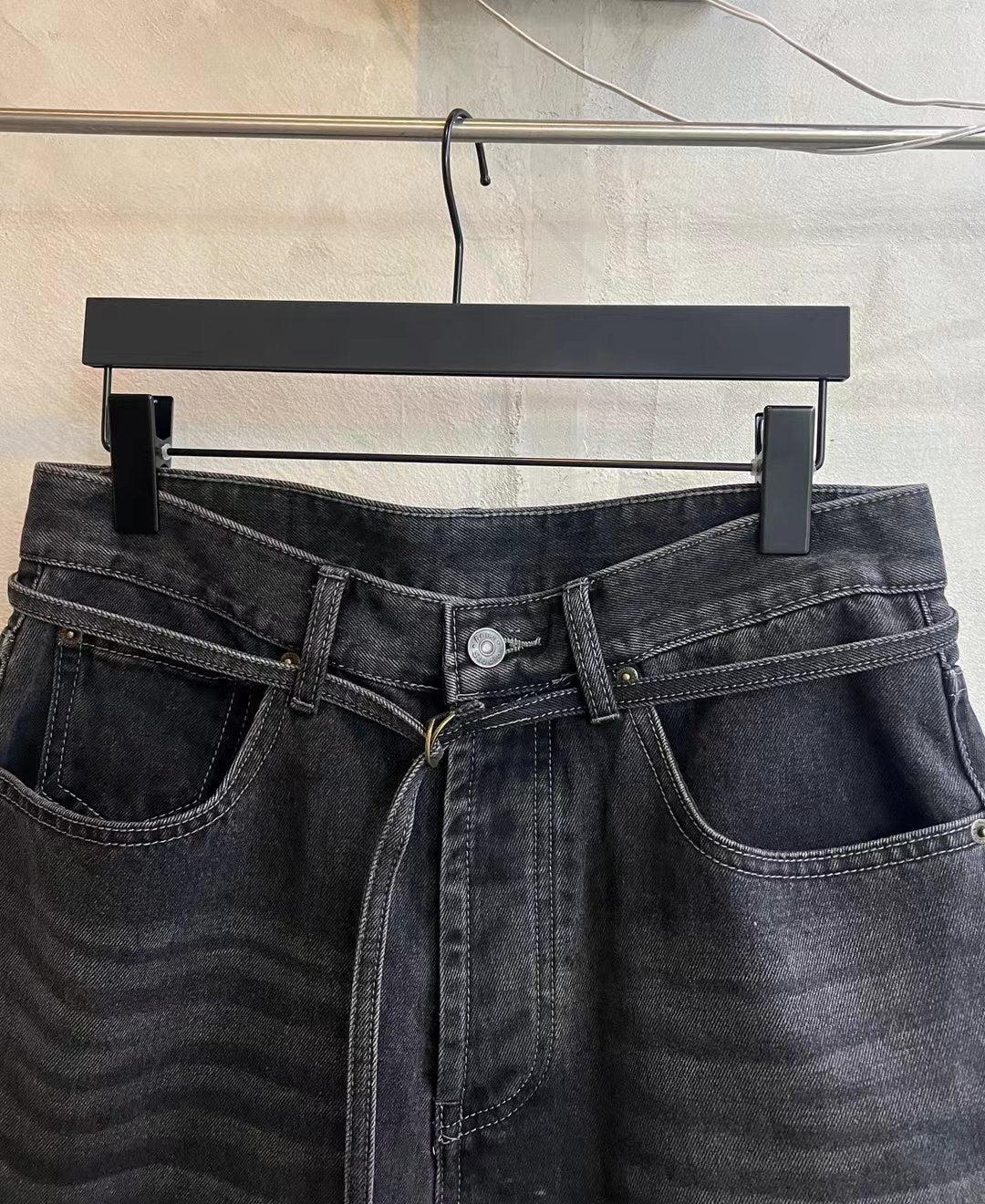 Dark wash denim shorts close-up: front pockets, button fly, and waist tie drawstring
