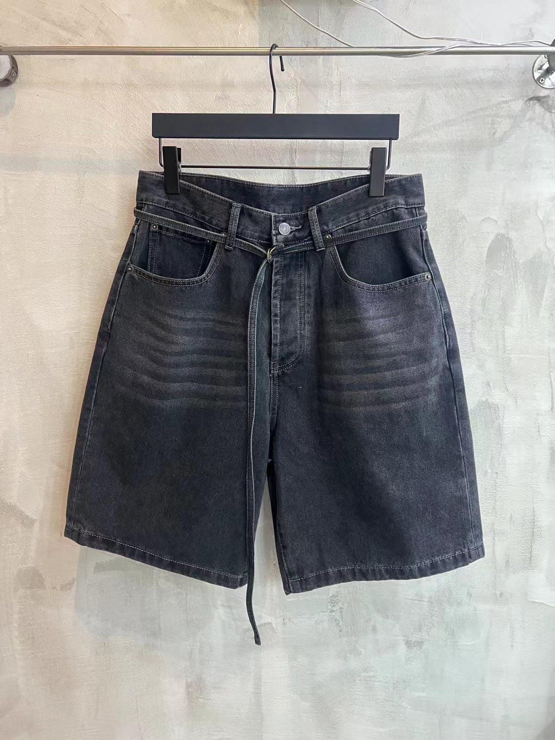 Dark wash denim shorts with belt loops, front pockets, and tied waist drawstring