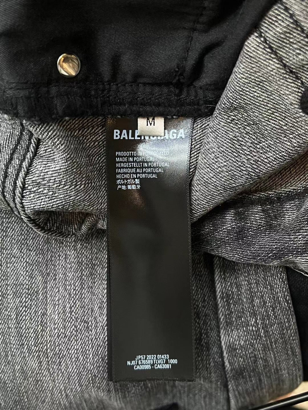 Denim pants close-up of waistband and inner care label, black and gray denim.