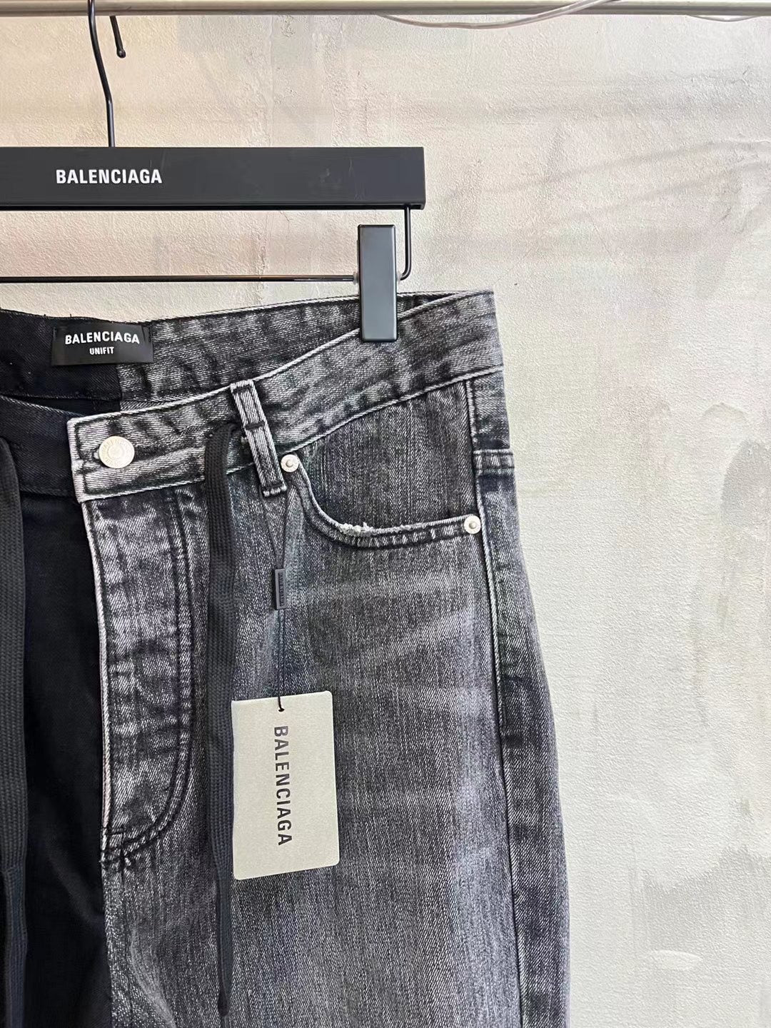 Denim pants with belt loops and front buttons, gray wash, wide leg.