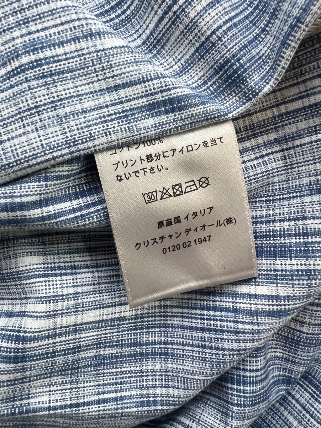 Fabric care label on blue-and-white patterned shirt