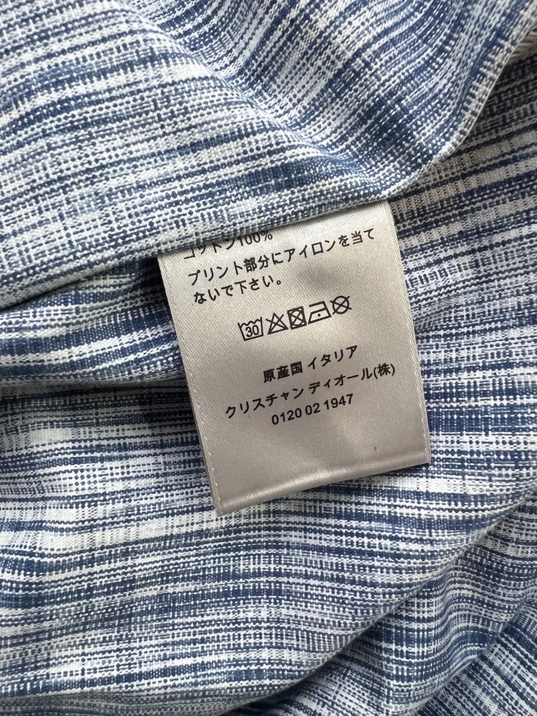 Fabric care label on blue-and-white patterned shirt