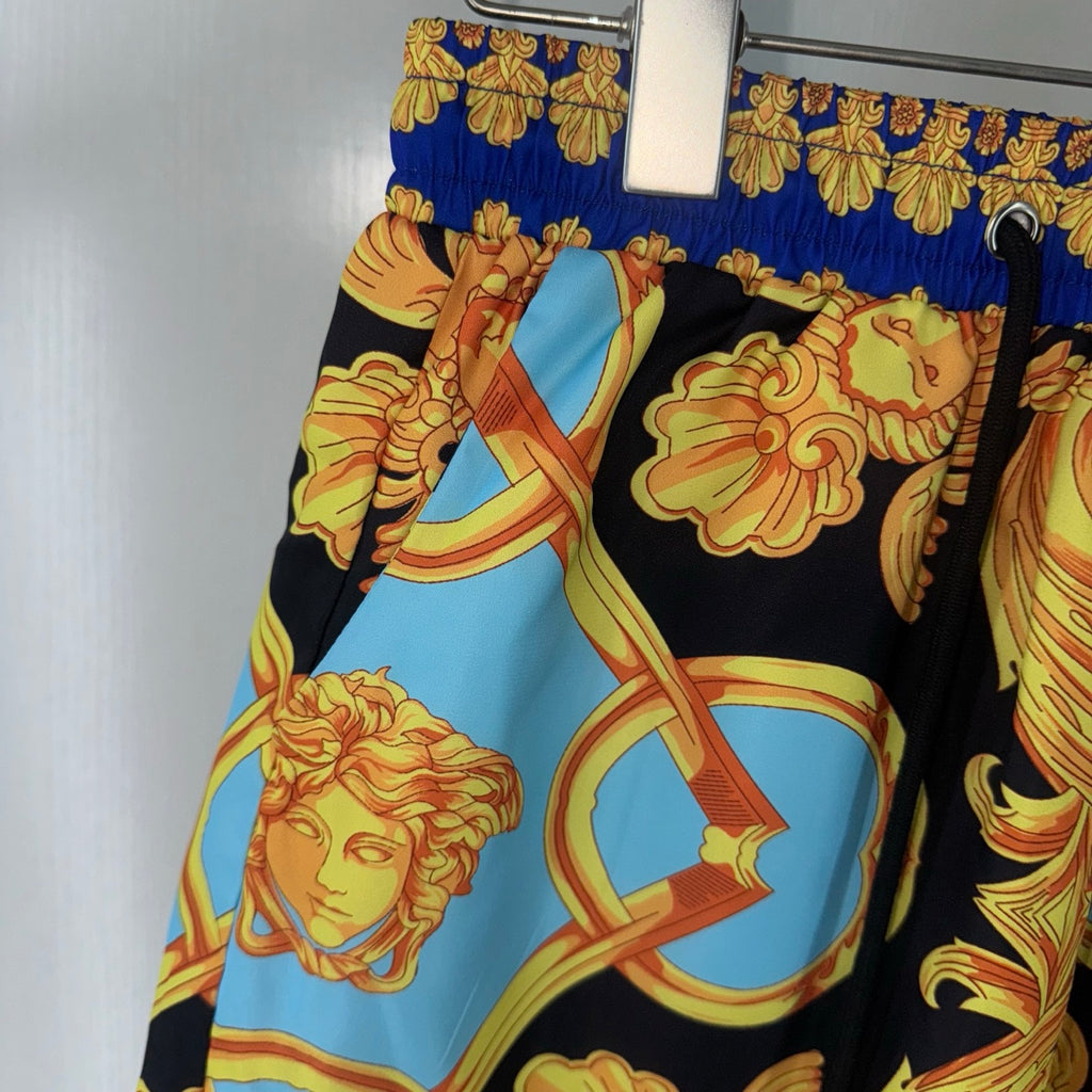 Versace shorts side view showing black base with light blue figure medallion print
