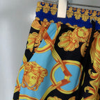Versace shorts side view showing black base with light blue figure medallion print
