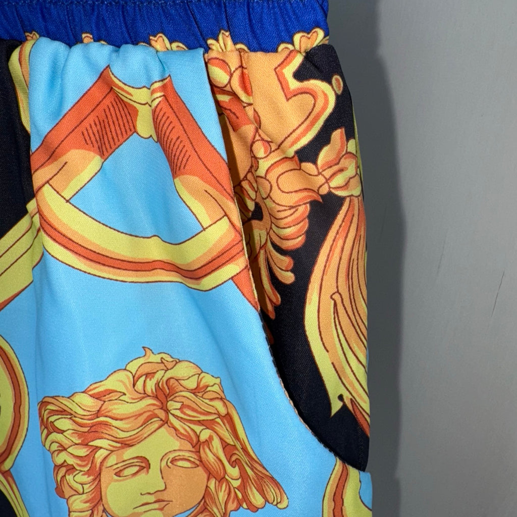Versace shorts pattern detail with light blue and gold baroque portrait elements