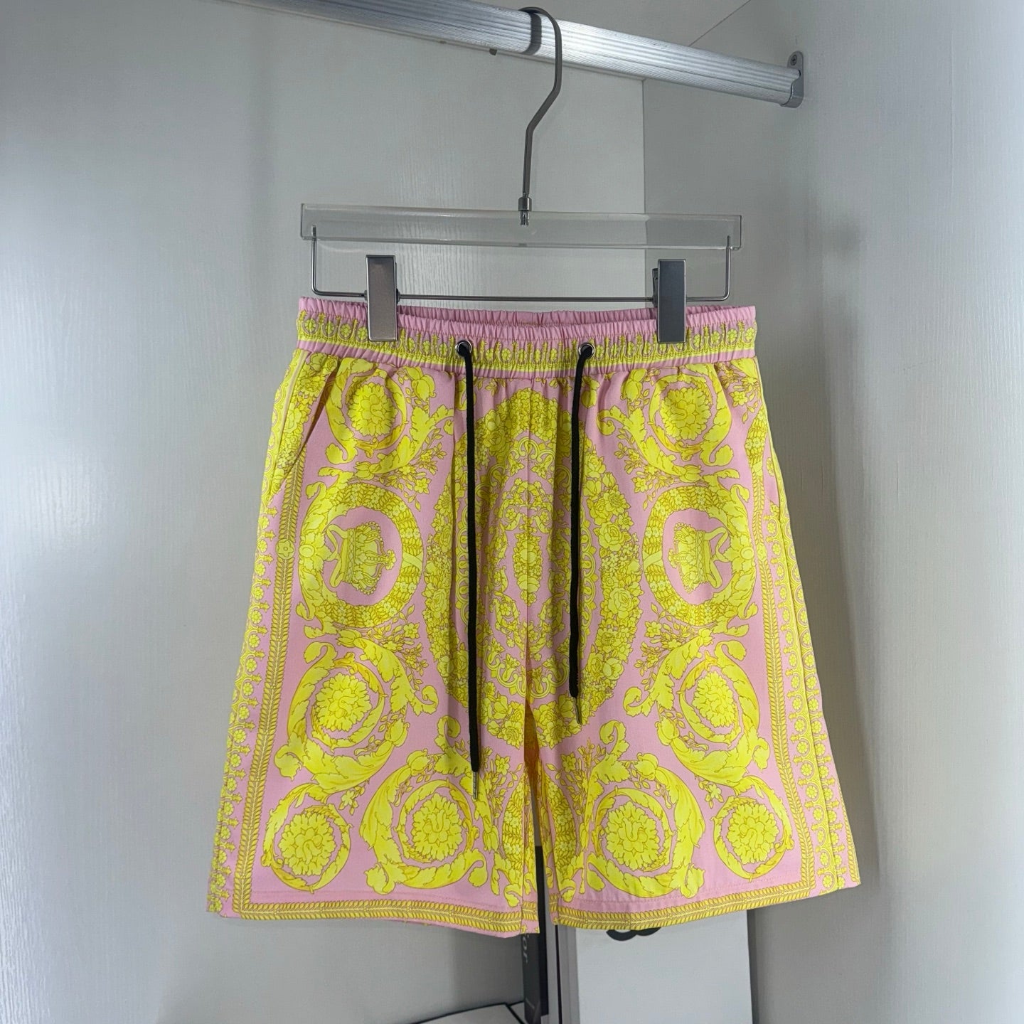 Versace shorts in yellow and pink baroque print, elastic waistband with black drawstring.