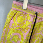 Versace shorts close-up showing pink elastic waistband with yellow ornate pattern.