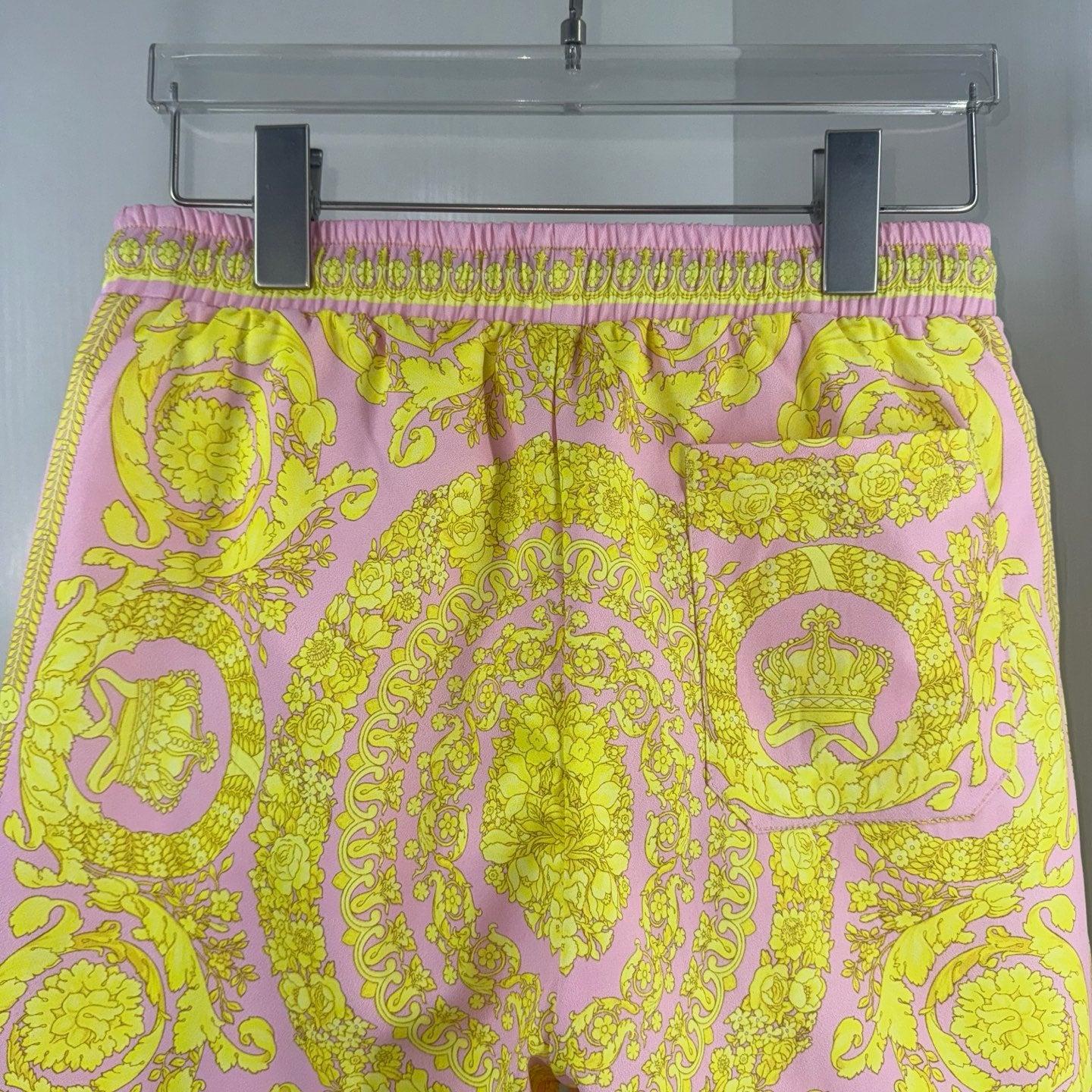 Versace printed shorts with pink elastic waistband and yellow ornate medallion pattern