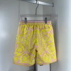 Versace shorts with yellow-and-pink ornate pattern, elastic waist and black drawstring.