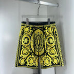 Black and yellow baroque print shorts with drawstring waist and scalloped hem trim