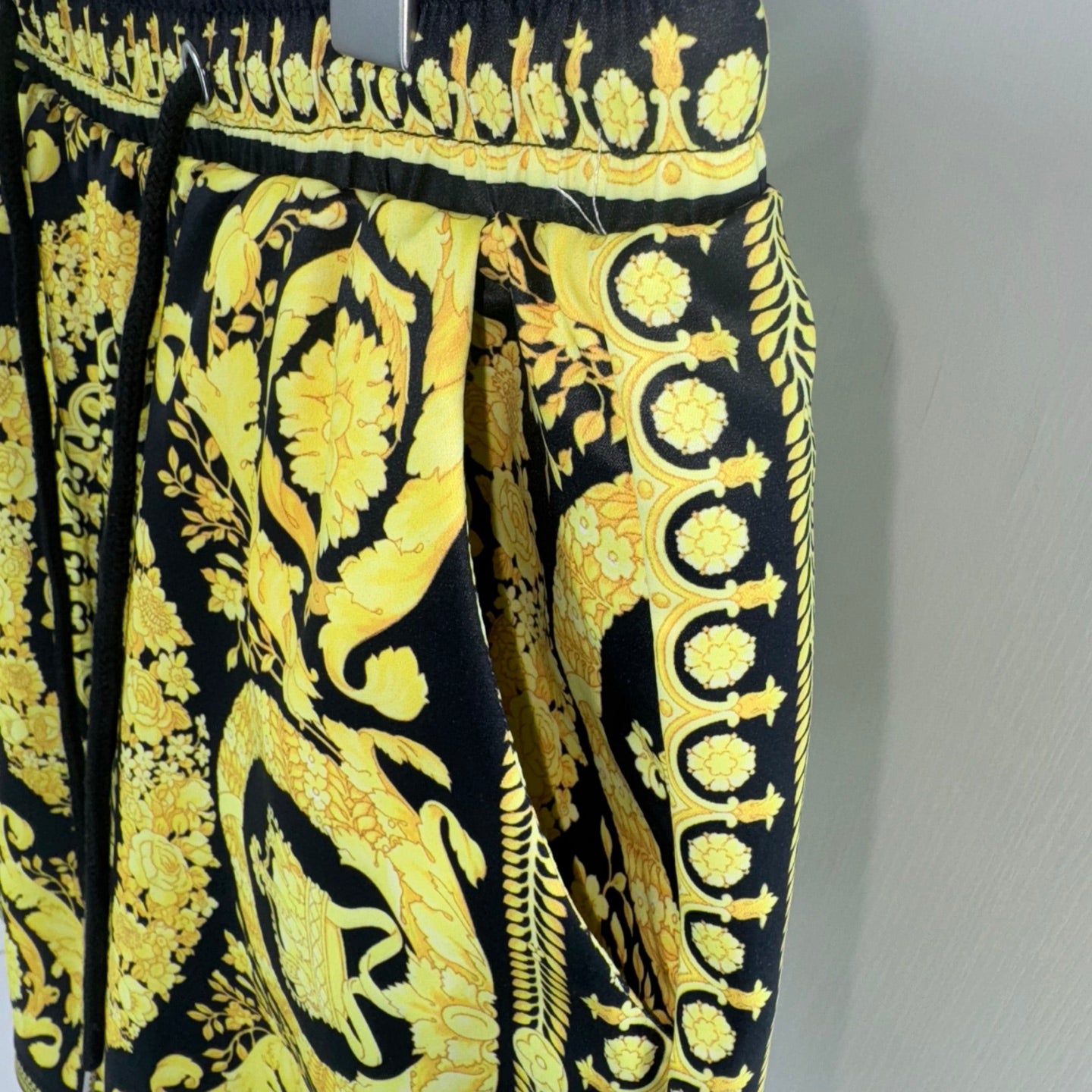 Black and yellow baroque print shorts with elastic waistband and decorative border trim
