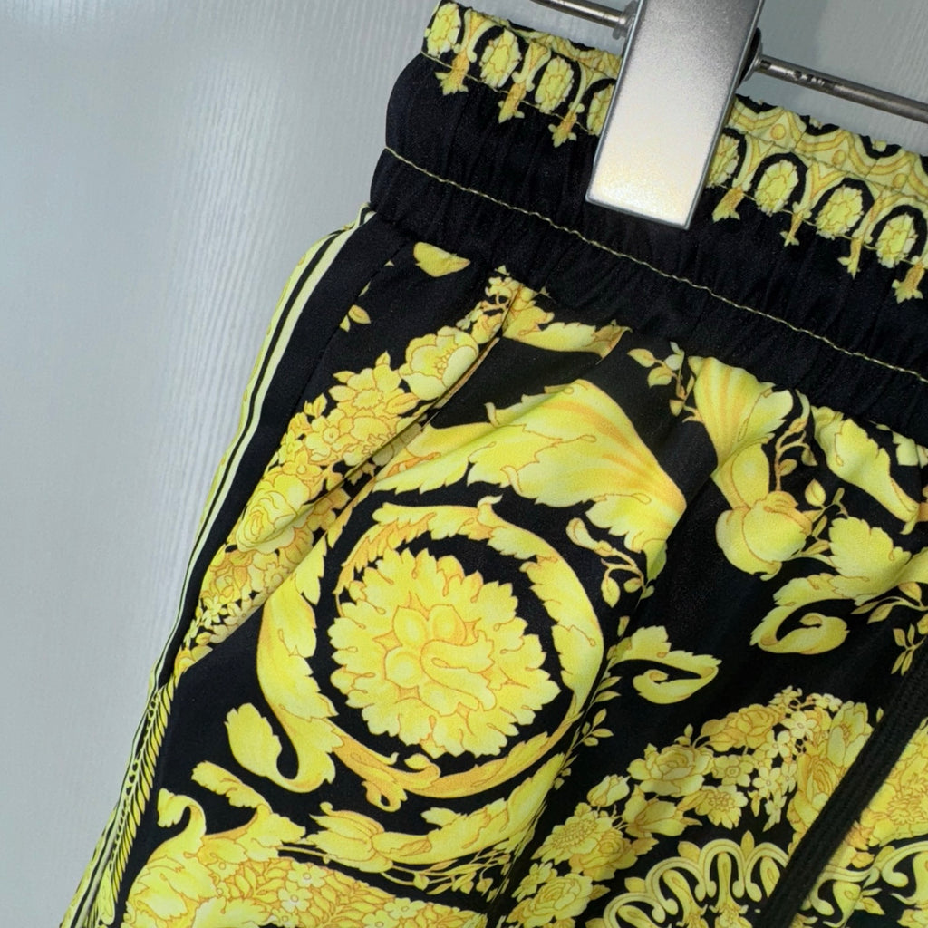 Black shorts with bold yellow floral and paisley print, side seam and elastic waist detail