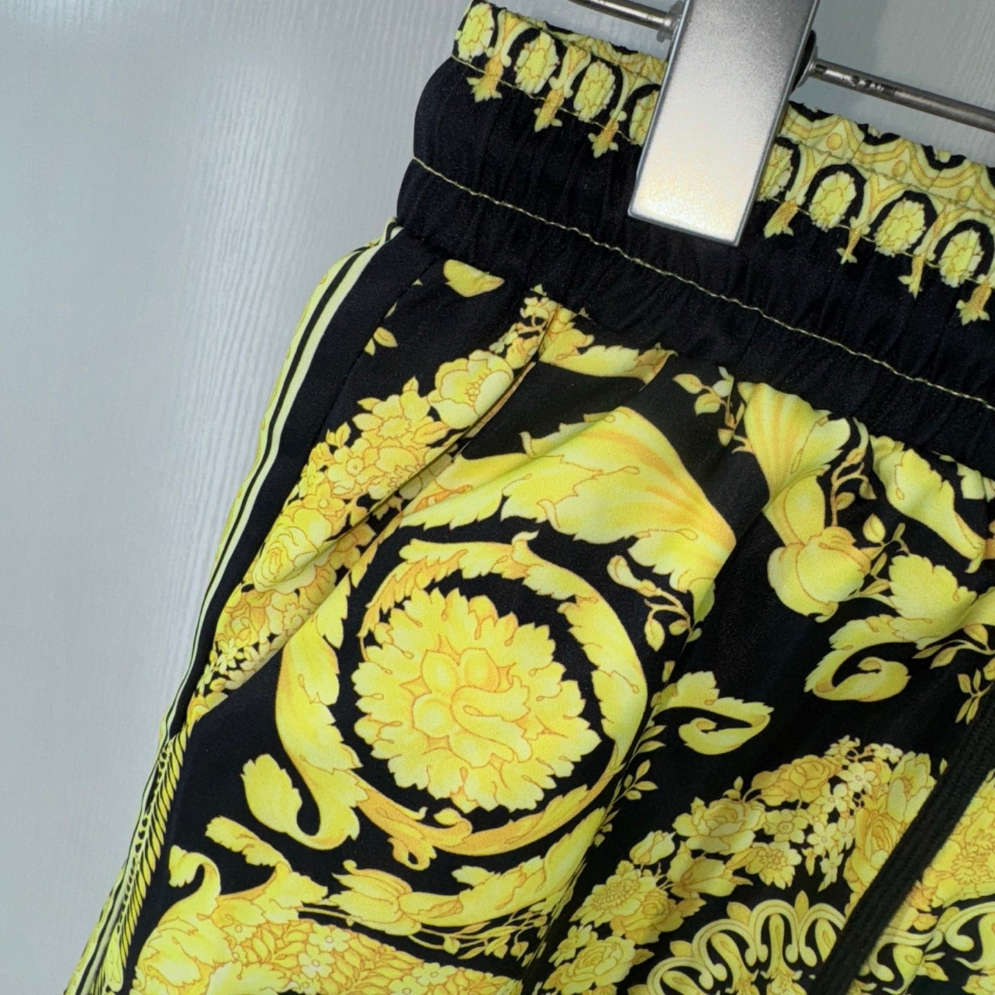 Black shorts with bold yellow floral and paisley print, side seam and elastic waist detail