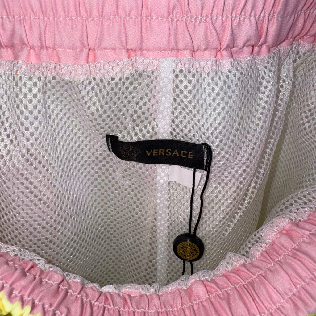 Versace white shorts close-up with fabric mesh texture and black brand size label.