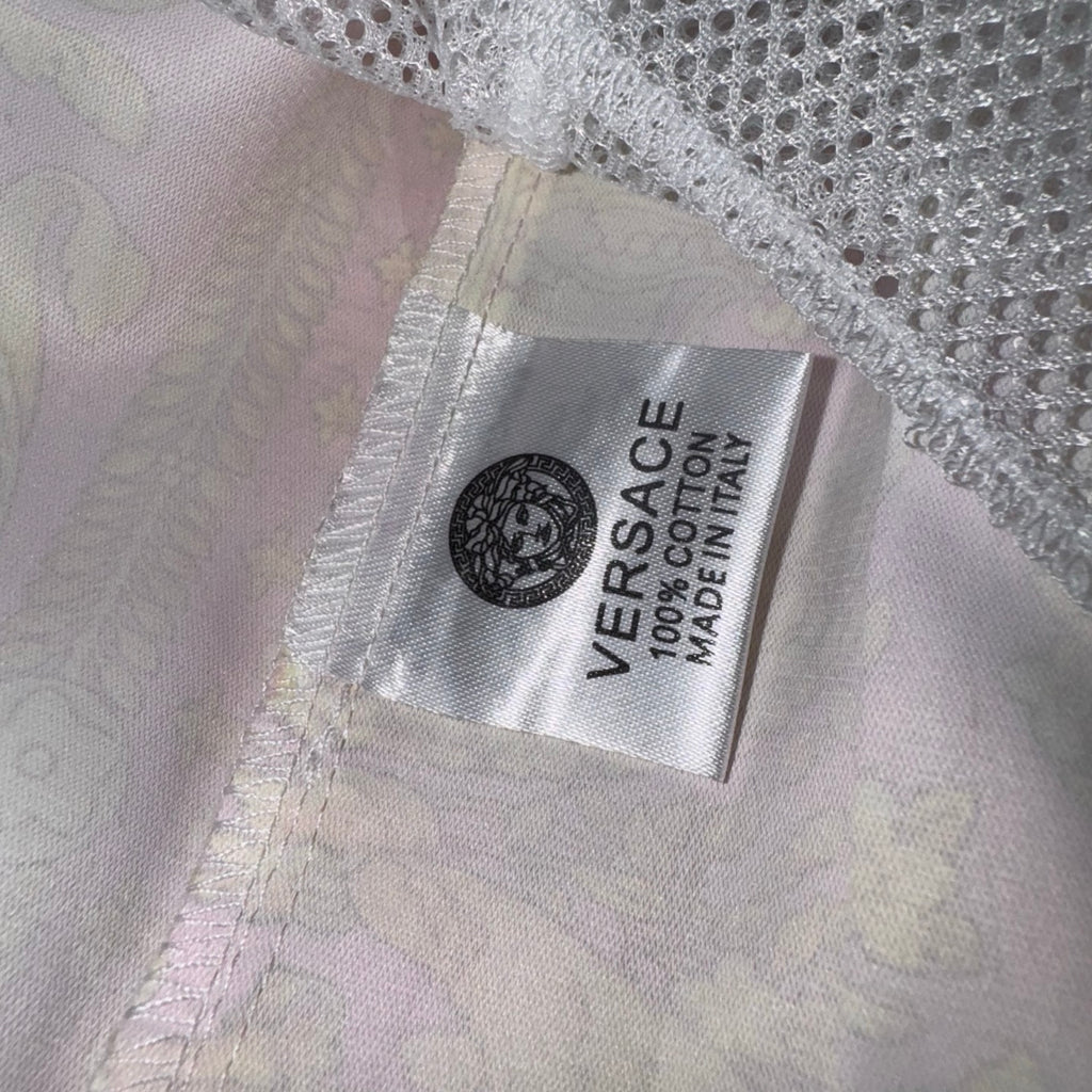Versace white shorts inner care label with printed brand and made information.