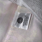 Versace white shorts inner care label with printed brand and made information.