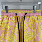 Versace shorts on hanger with purple-pink elastic waistband and yellow baroque print.