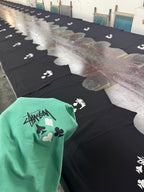 Green graphic T-shirt with playing card icons and Stussy-style logo