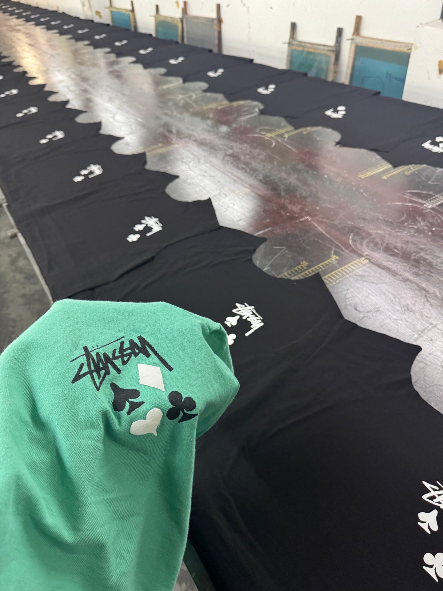 Green graphic T-shirt with playing card icons and Stussy-style logo