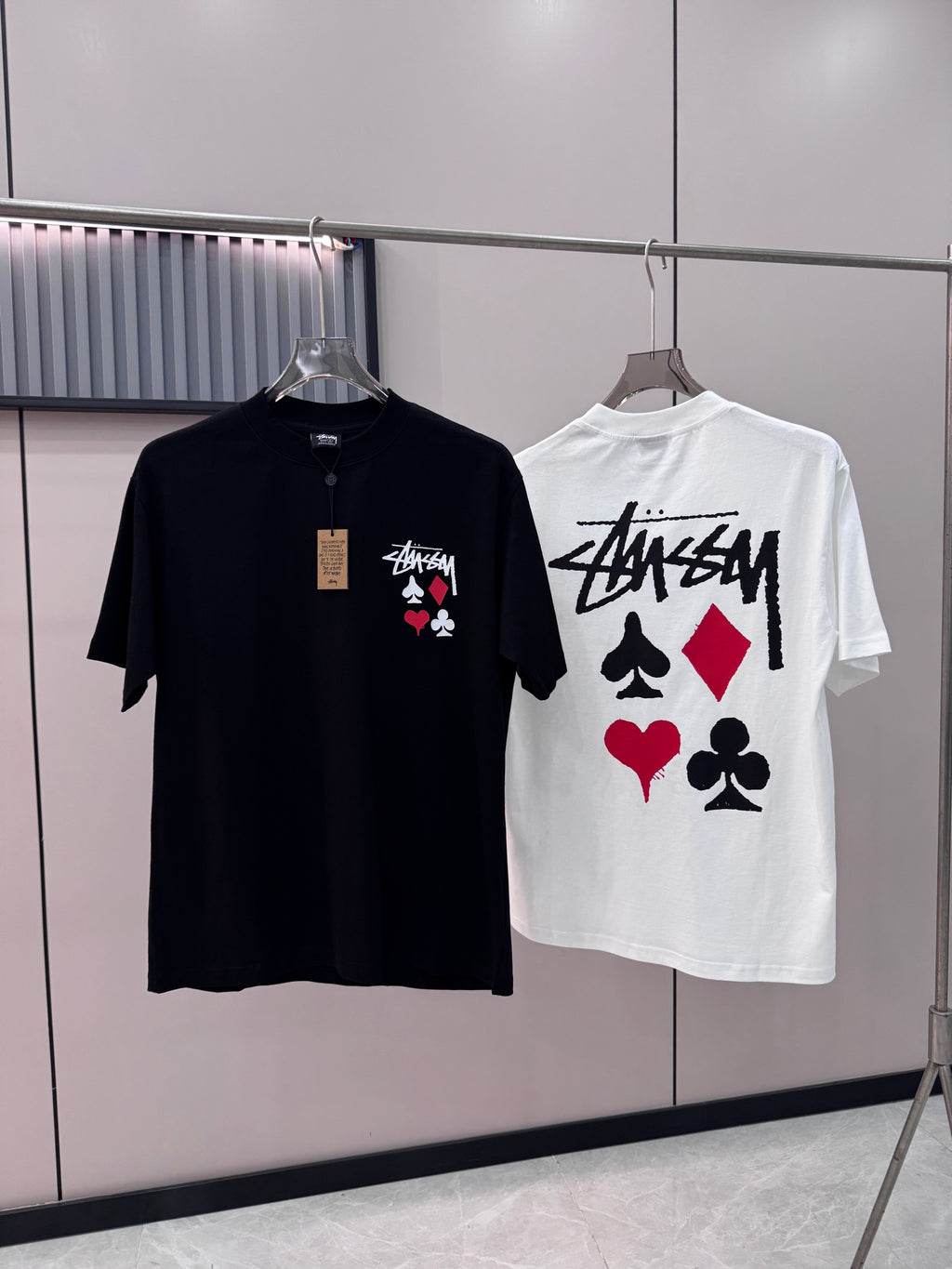 Black short-sleeve T-shirt with chest graphic of playing cards on hanger