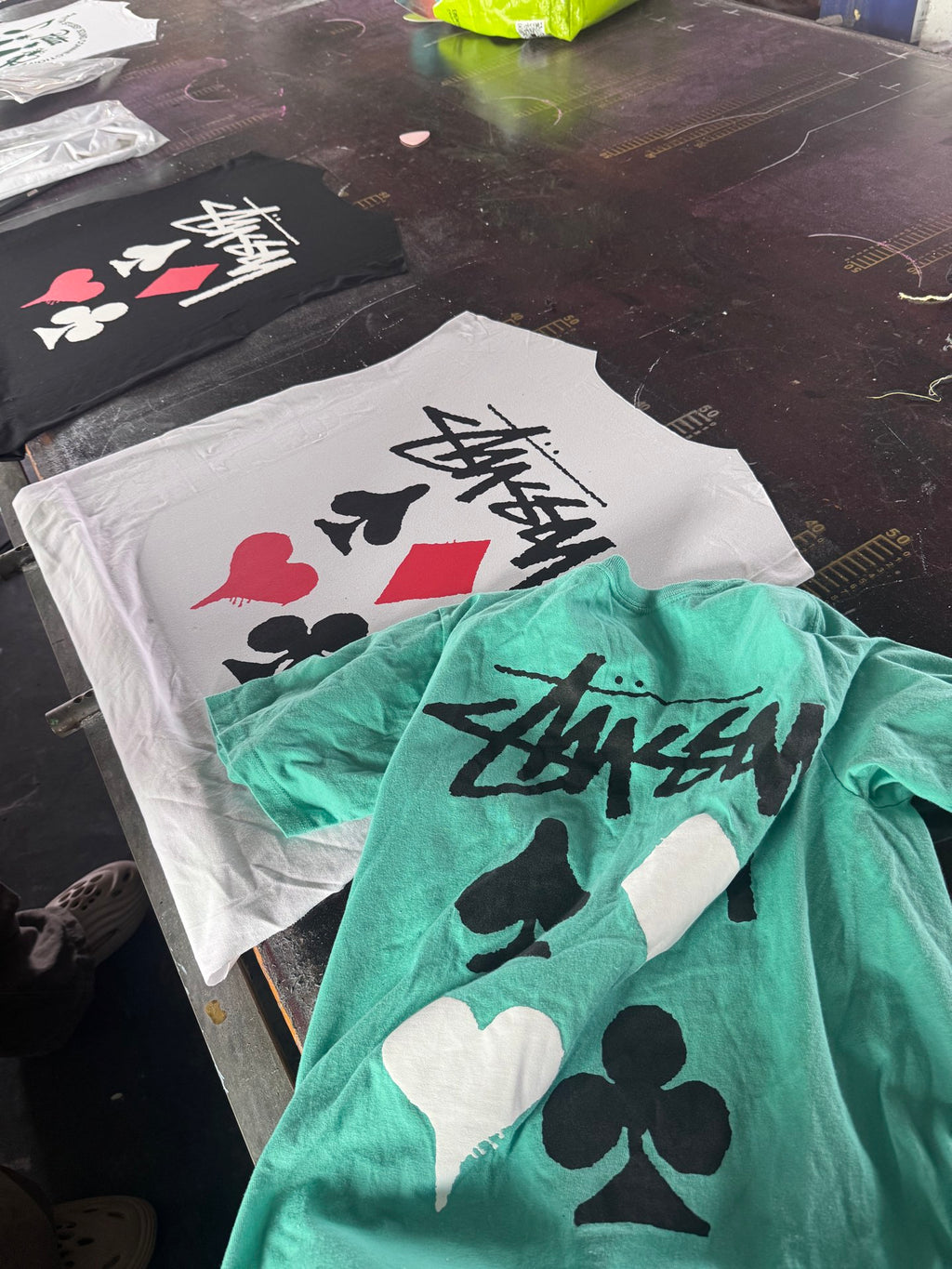 White and green graphic T-shirt tops with playing card icons and Stussy-style logo
