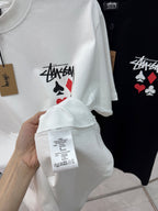 White T-shirt with Stussy playing-card graphic on front, sleeve and neckline detail