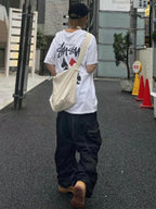 White graphic T-shirt with Stussy-style logo and diagonal hand-drawn print