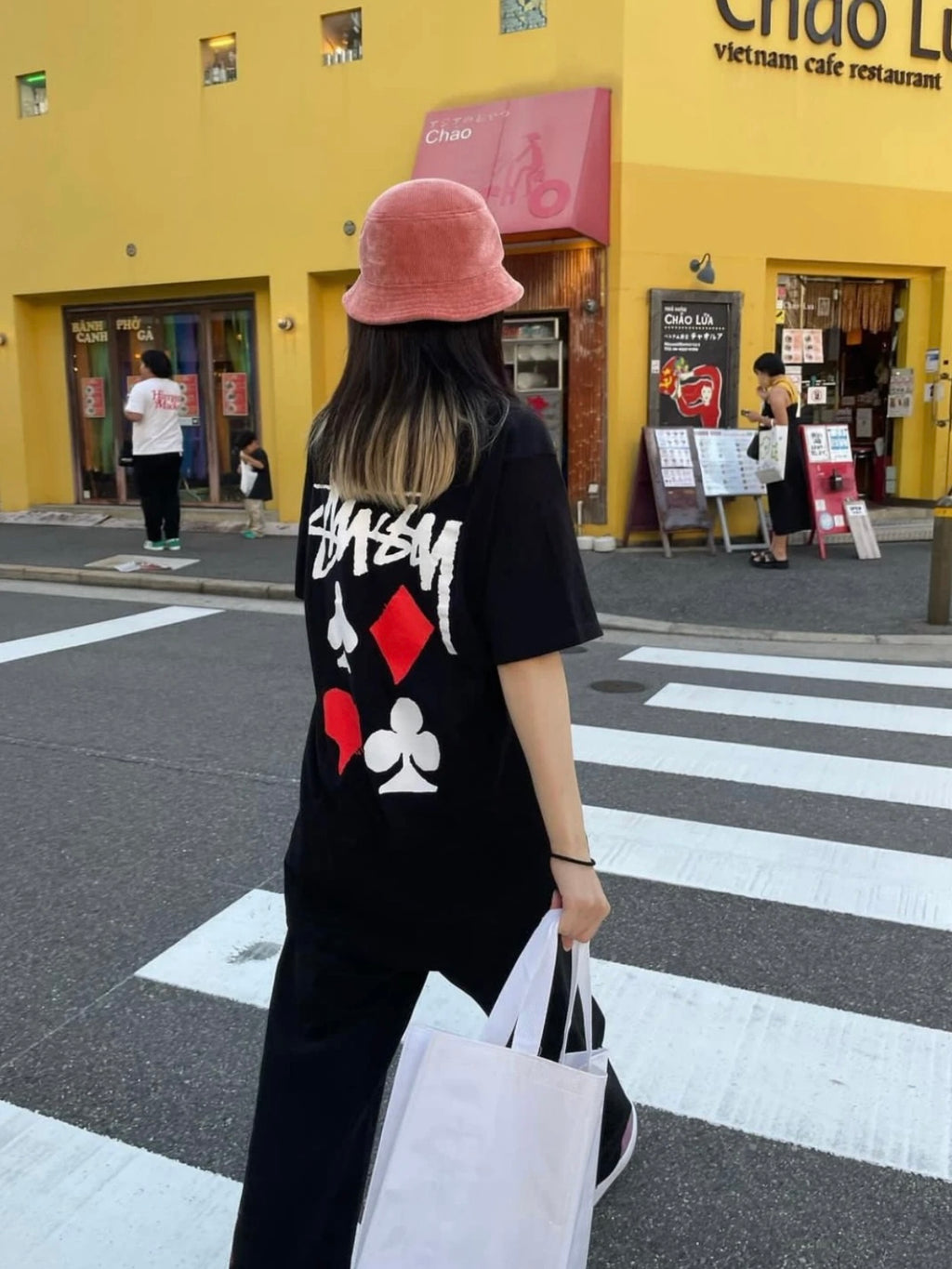 Black graphic T-shirt with playing card icons and Stussy-style logo on back