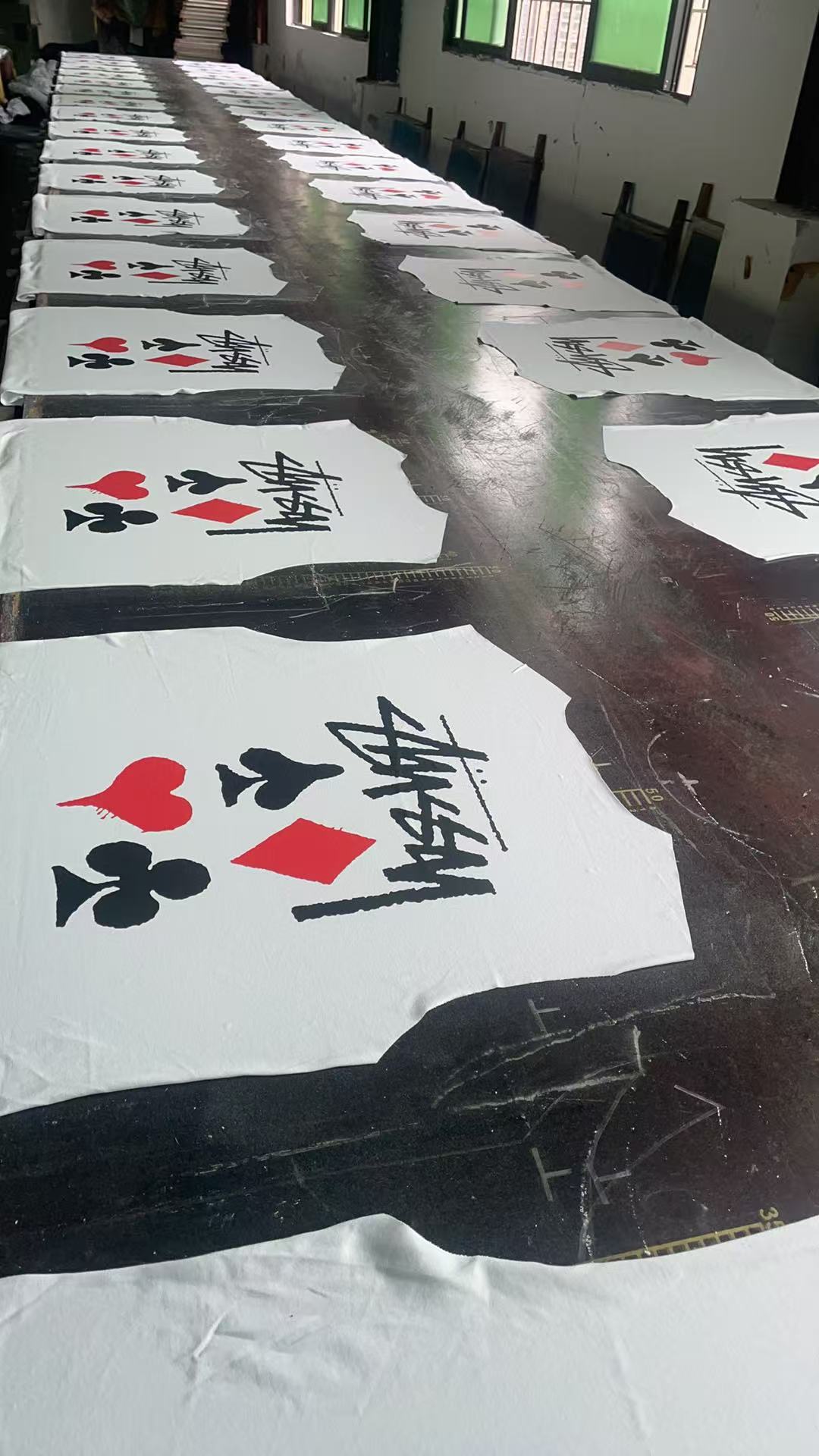 Pack of white graphic T-shirts with playing card icons and Stussy-style script