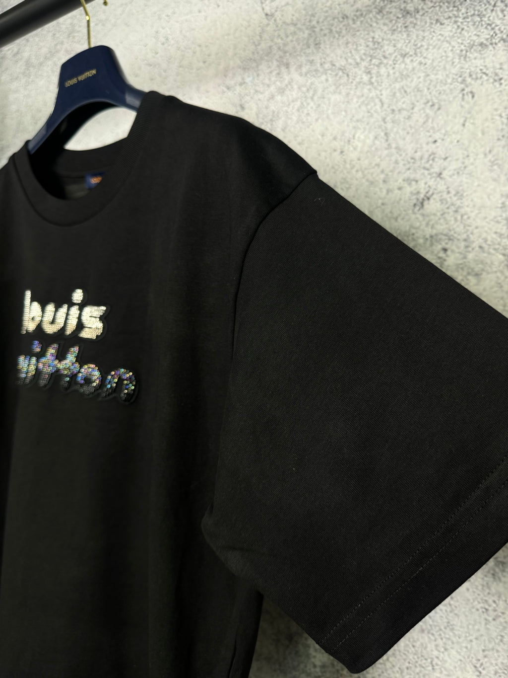 Black short-sleeve T-shirt on a hanger with rhinestone "louis" front graphic