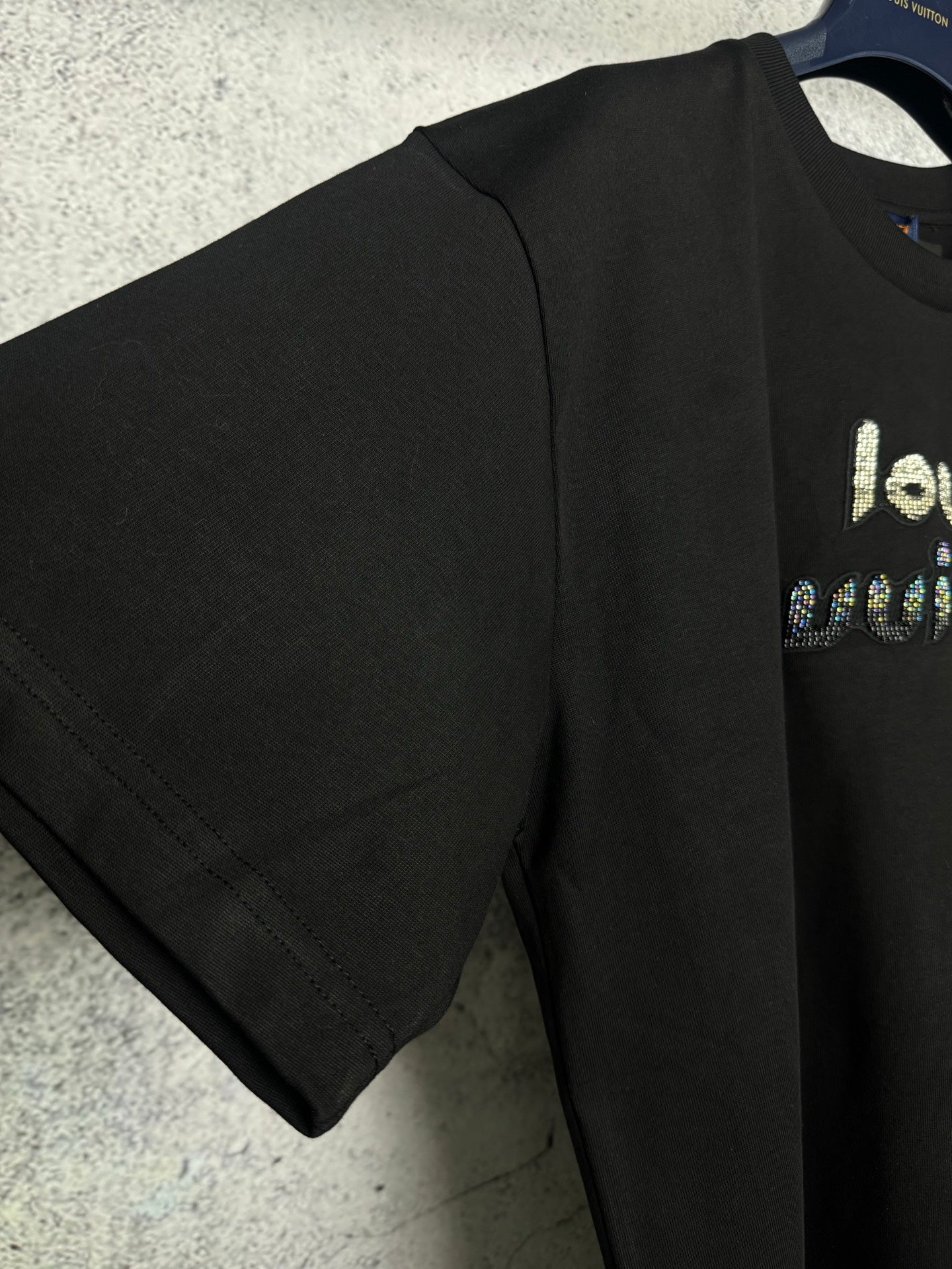 Black short-sleeve T-shirt with rhinestone logo, side and sleeve view