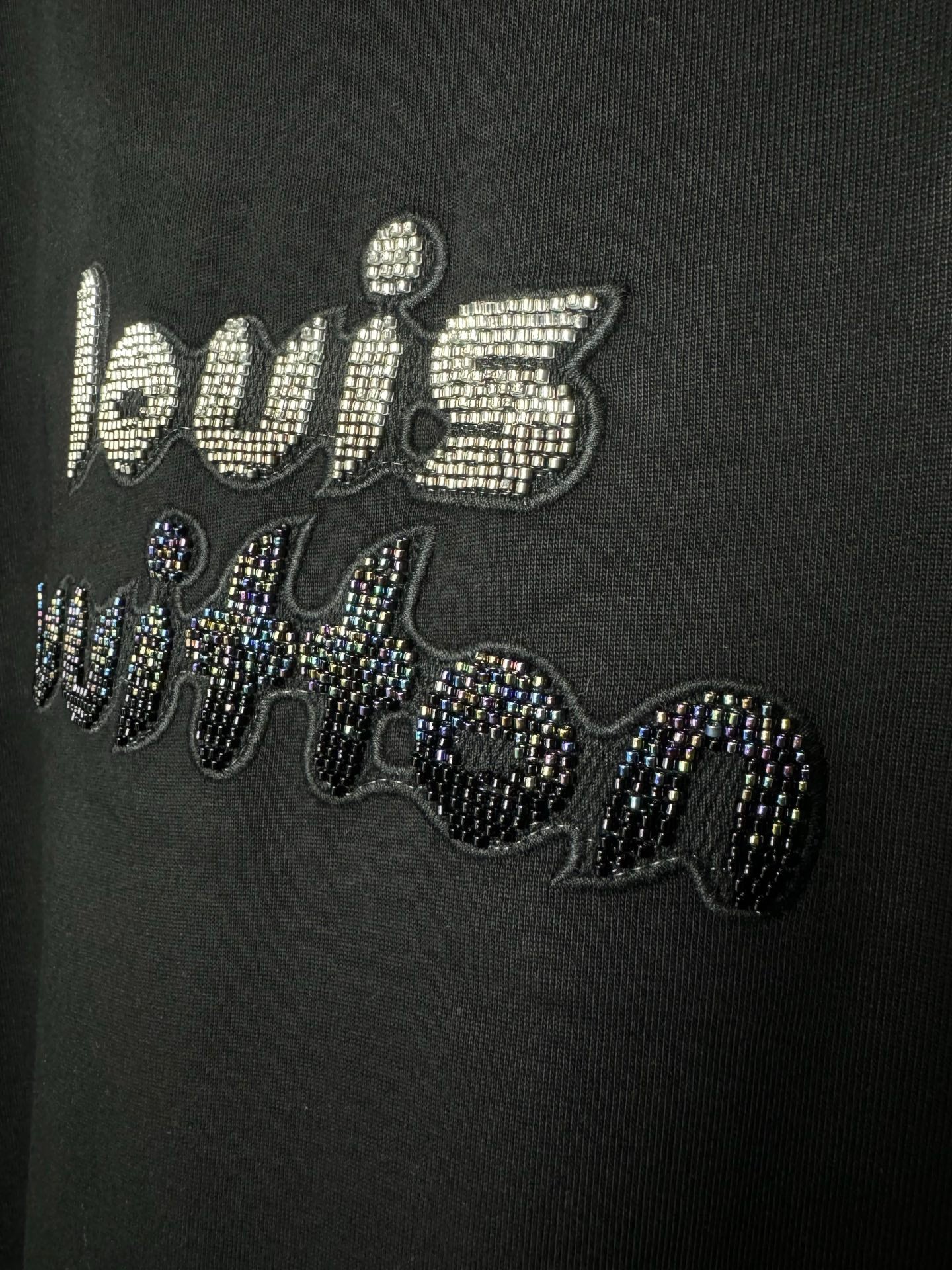 Close-up of black T-shirt rhinestone "world" text graphic