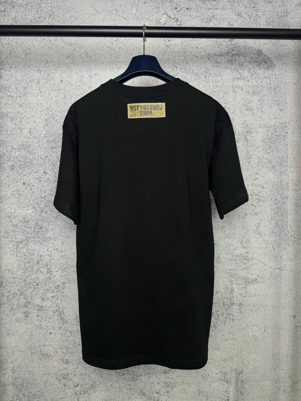 Black short-sleeve T-shirt back view with yellow brand label at the upper back
