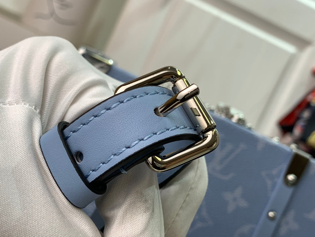 Men's Louis Vuitton bag buckle and D-ring detail on light blue strap