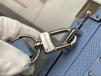 Men's Louis Vuitton bag strap clip detail in light blue with gold-tone hardware