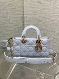 Quilted light blue handbag with gold-tone hardware, top handles, and crossbody strap