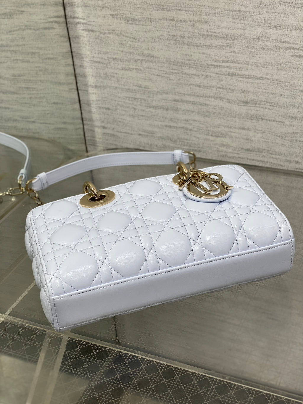 Light blue quilted top-handle handbag with gold-tone rings and strap