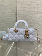 Light blue quilted handbag with double handles, gold-tone hardware, and shoulder strap