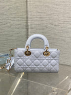 Light blue quilted handbag with top handles and gold-tone rings, with shoulder strap