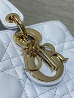 Gold-tone logo charm and clasp on quilted light blue handbag hardware