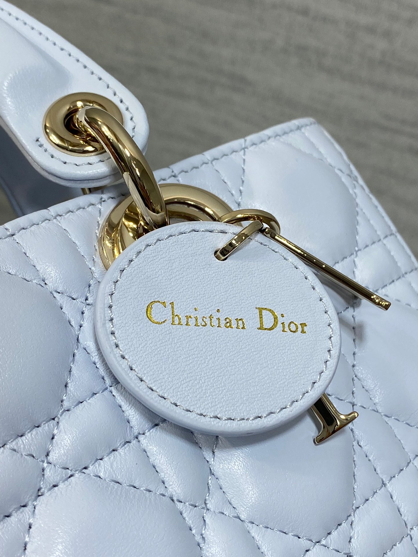 Quilted light blue handbag charm with Christian Dior logo and gold clasp